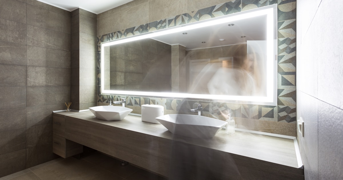 The washroom has a modern design. Against the background of a woman washes her hands
