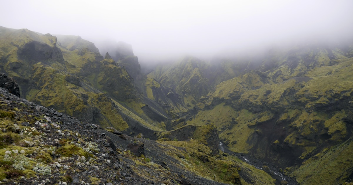 a foggy mountain with a river running through it