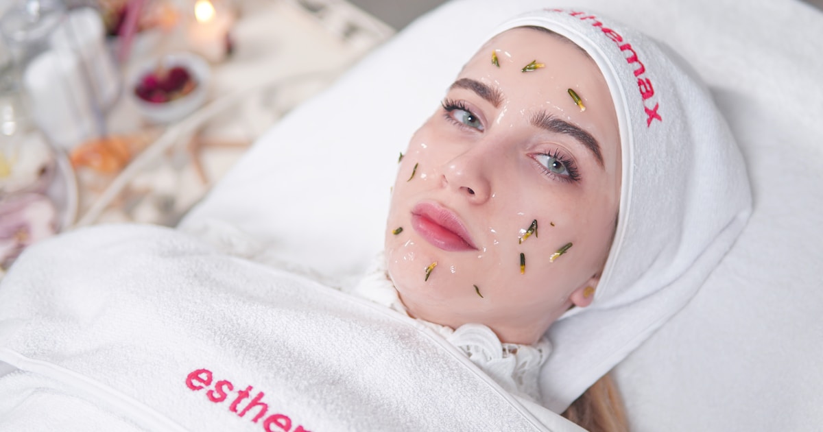 a woman laying in a bed with a sheet on her head