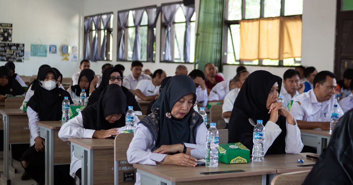 People sitting at desks in a classroom setting.