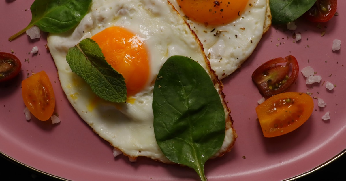 Fried eggs with vegetables on a plate.