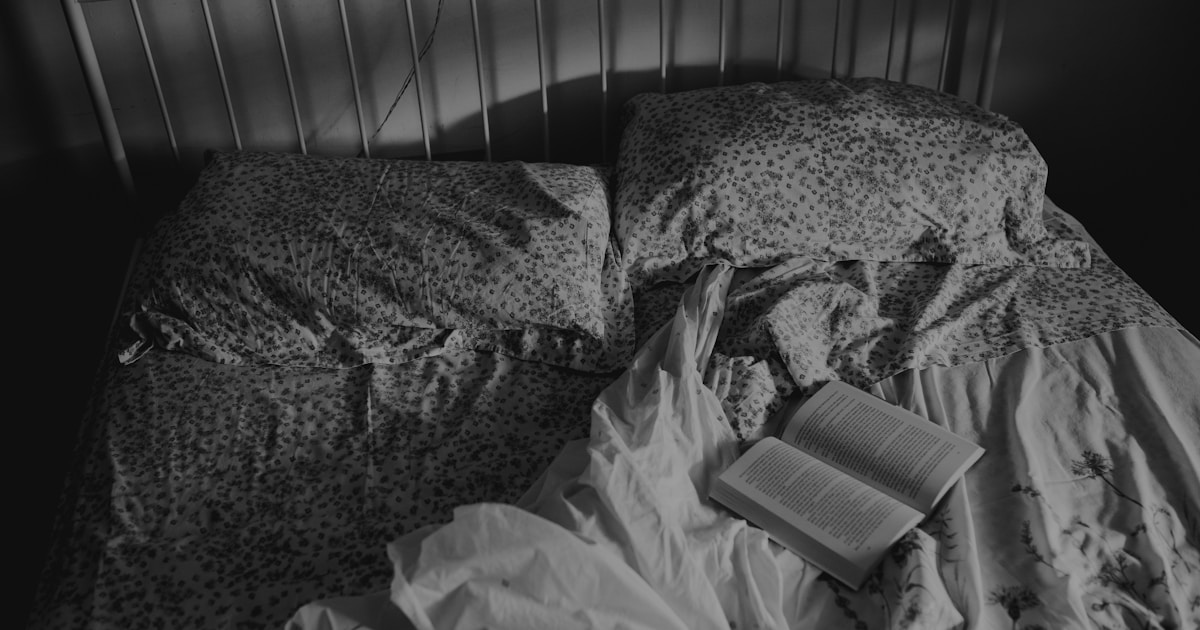 a book is laying on a messy bed