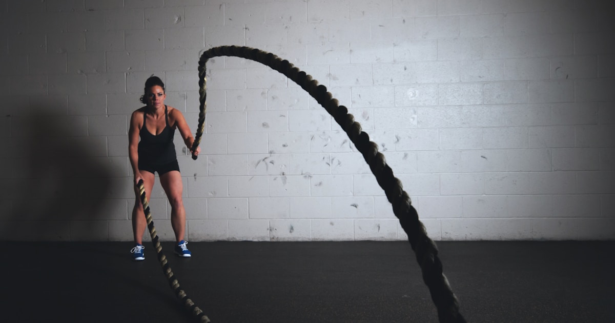 Woman working out with battle ropes and getting fit!