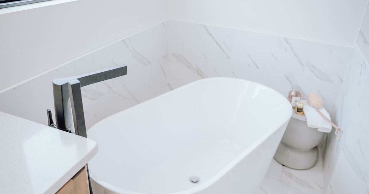 a white bath tub sitting in a bathroom next to a toilet