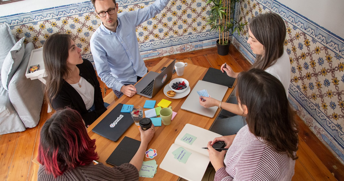 a group of people sitting around a wooden table