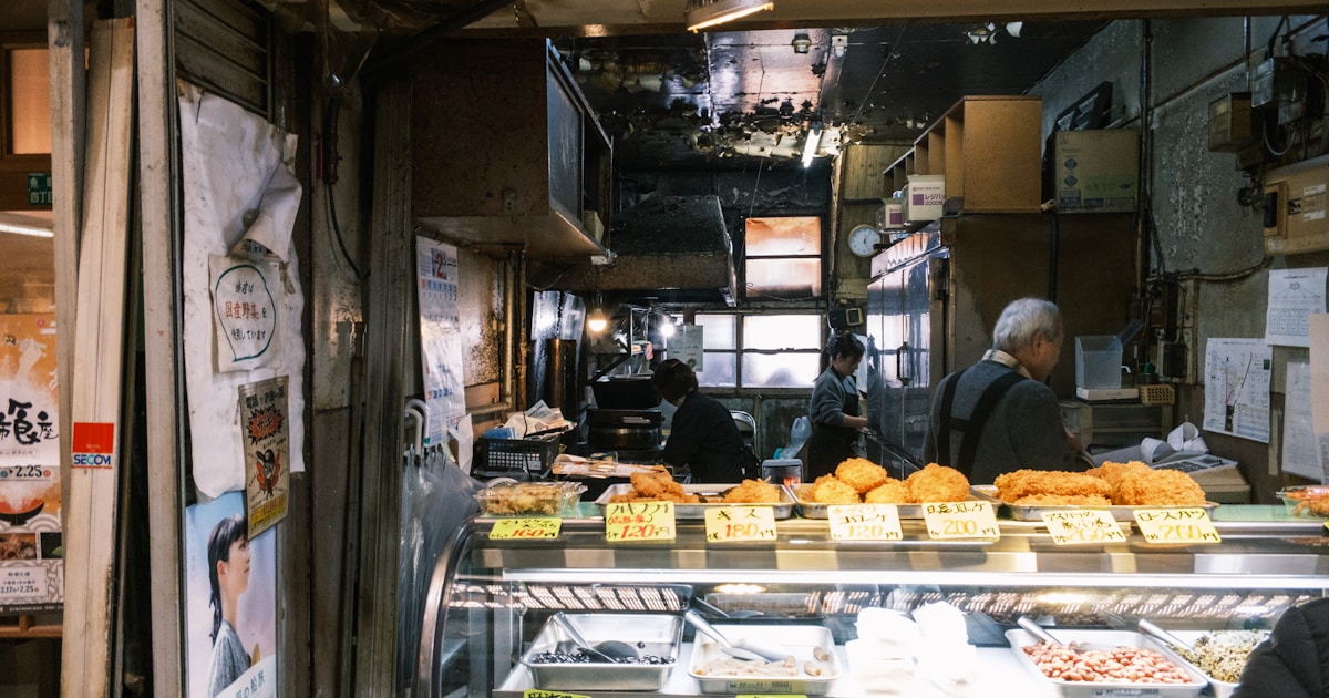 a man standing in front of a display case filled with food