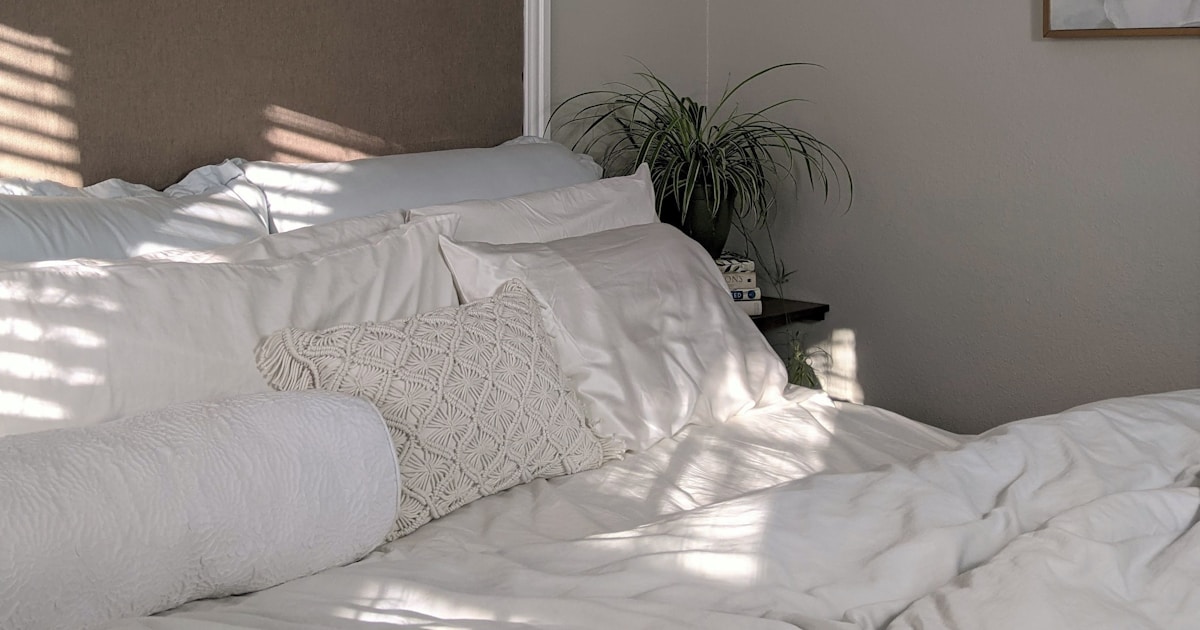 white bed linen near green plant