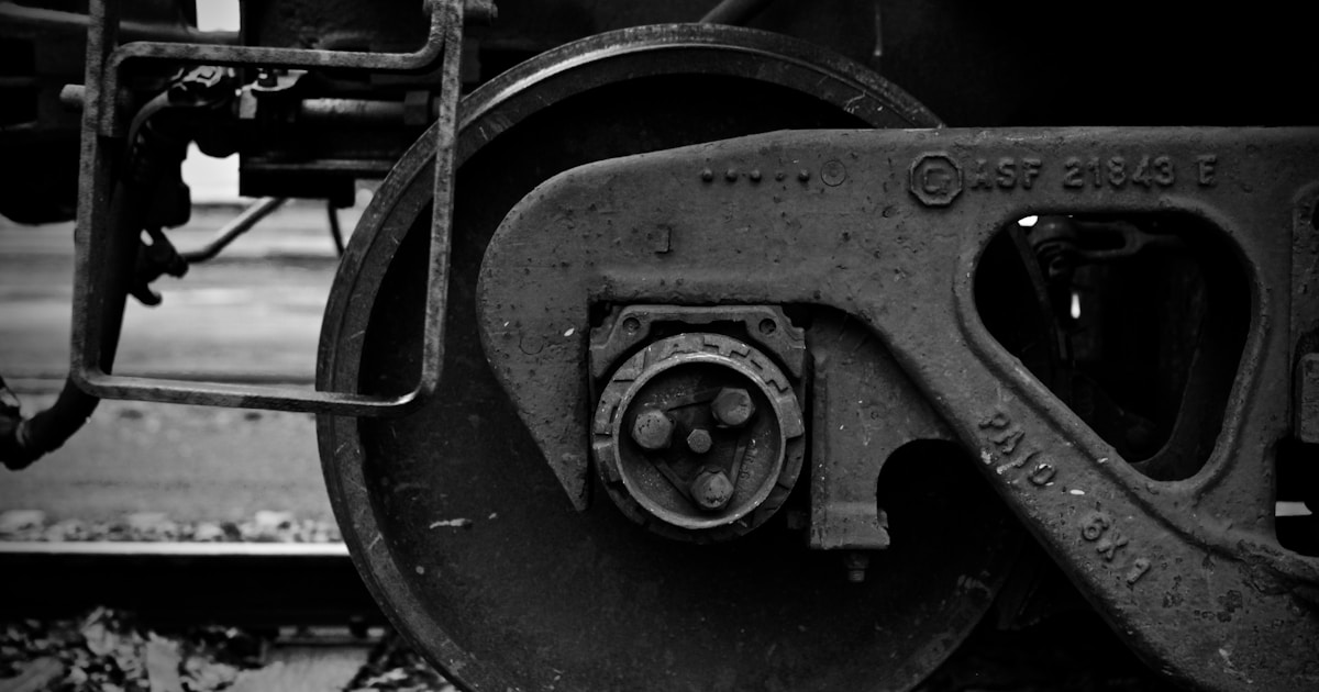 a black and white photo of the wheels of a train