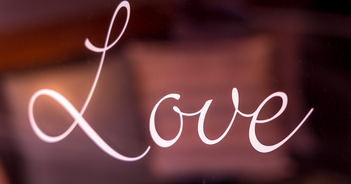The word love on a window, with a pink background.