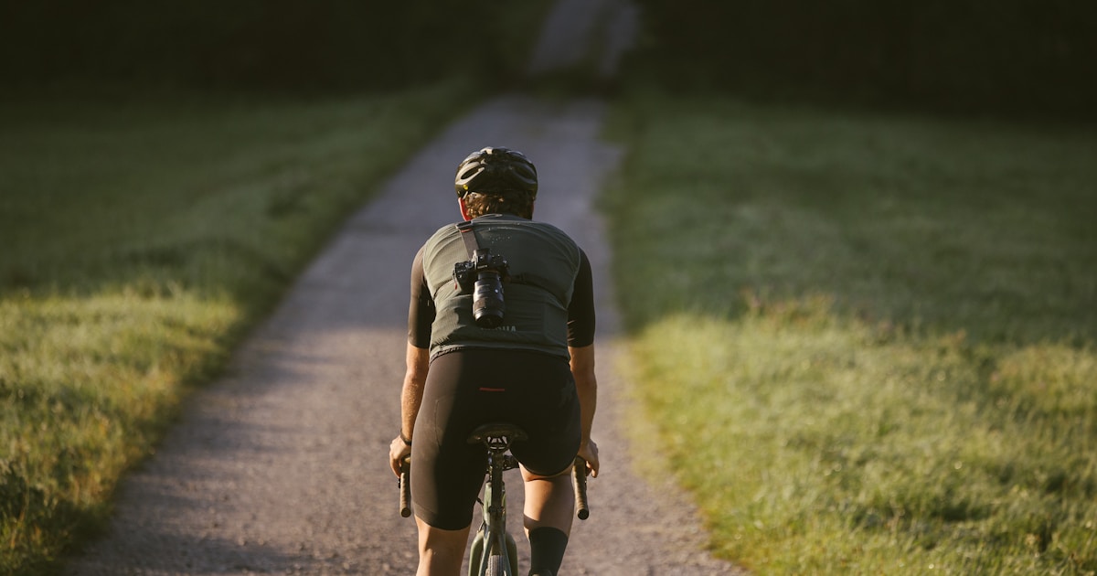A cyclist with his camera securely strapped to his back thanks to the Rille camera strap for cyclists.