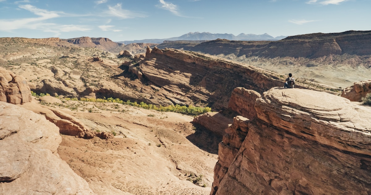 person sitting on brown mountain
