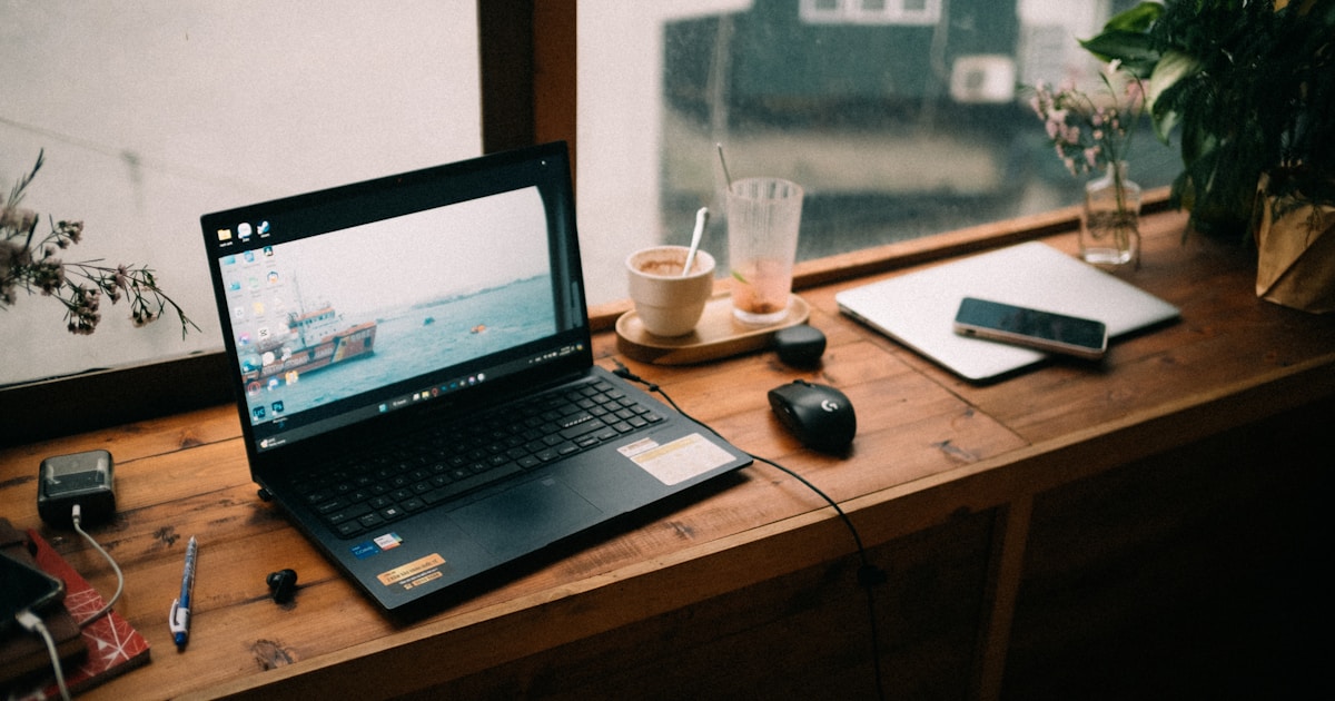 A laptop computer sitting on top of a wooden desk