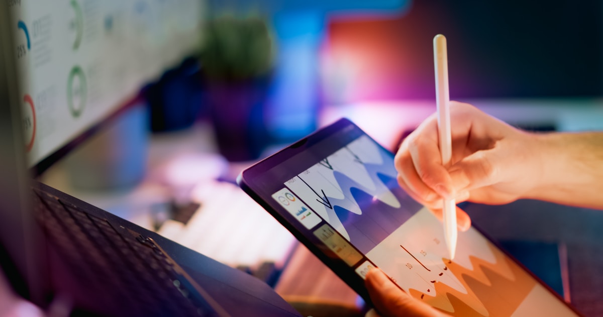Tablet analytics chart touchscreen data visualization concept showing hand using stylus to edit colorful graph in digital workspace environment